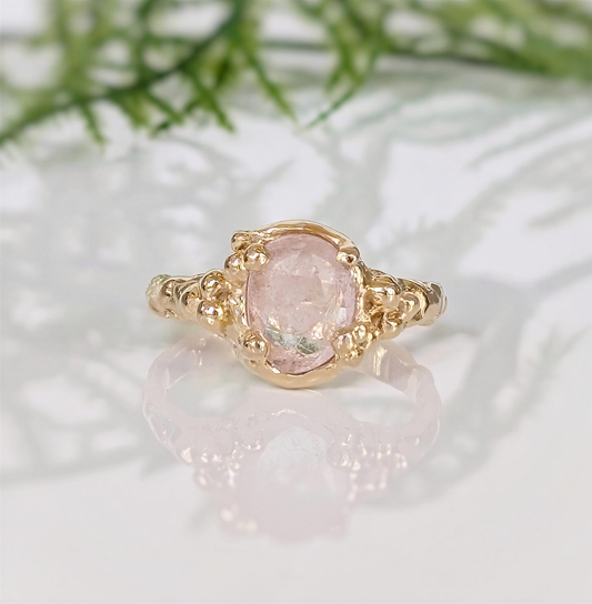 Handcrafted 14k gold ring featuring an oval rose cut pink Morganite, showcasing intricate details and natural elegance.