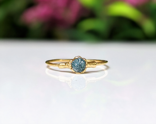 Raw blue diamond engagement ring on an 18k gold band, handcrafted and unique for special occasions.