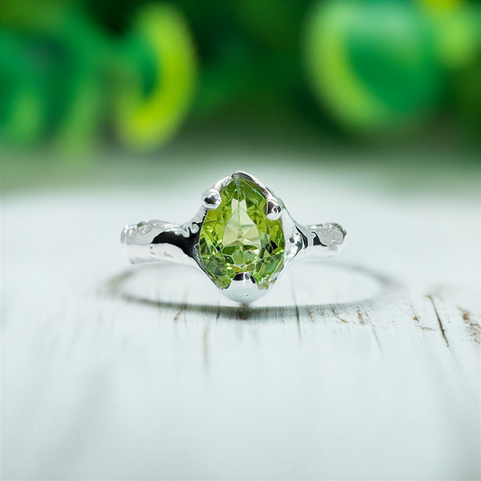 Handcrafted sterling silver ring featuring a rose cut peridot gemstone, elegant and rustic design.