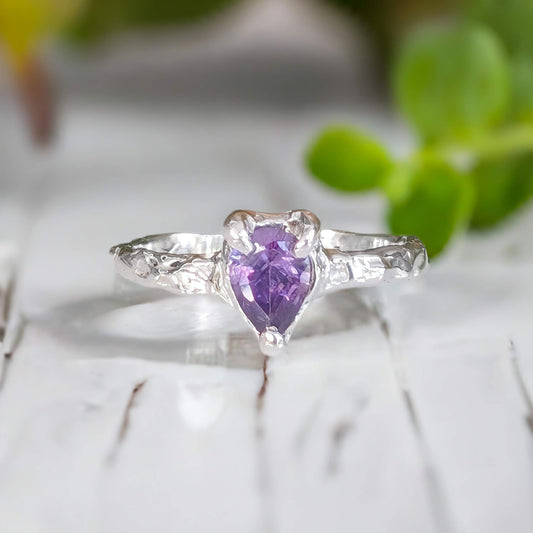Amethyst engagement ring in solid sterling silver with pear-shaped purple gemstone and textured band.