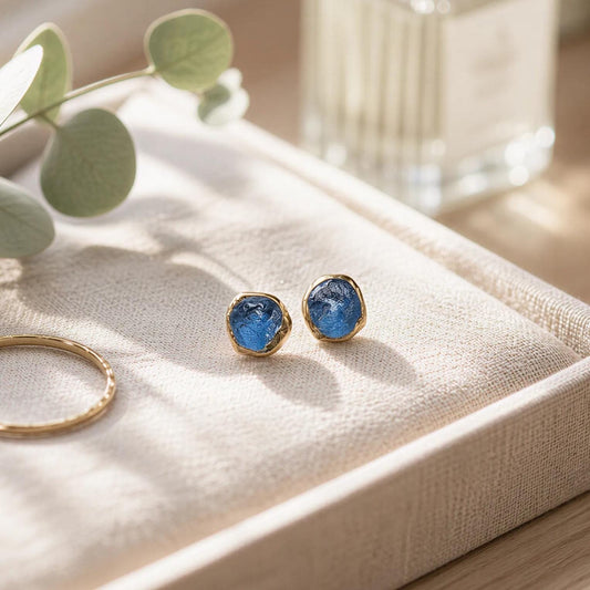 A pair of Teal blue Montana Sapphire stud earrings, set on a linen off-white jewelry tray