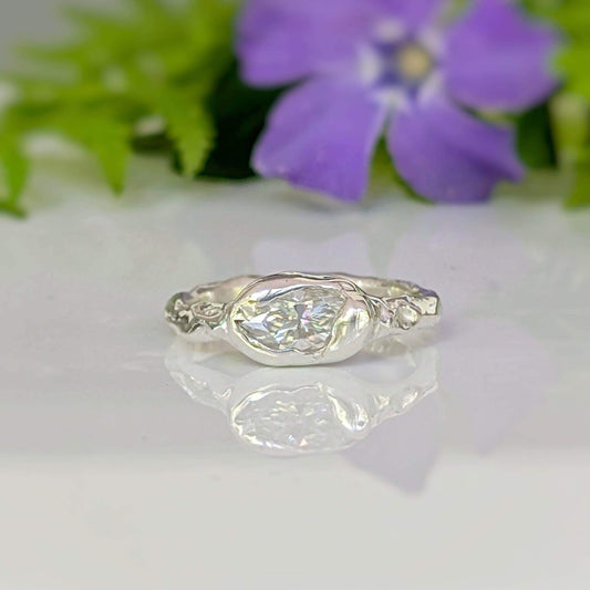Moissanite Engagement Ring - Sterling Silver Textured Band featuring a marquise Moissanite stone on a textured band.