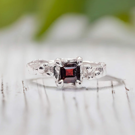 Red Garnet engagement ring in solid sterling silver with an organic textured band, featuring a square crystal centerpiece.