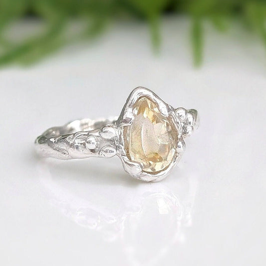 Handcrafted pear shape citrine silver ring with a textured band, showcasing natural charm and elegance.