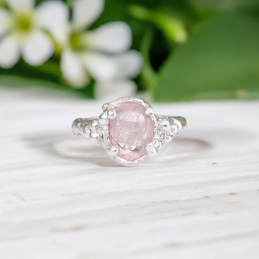 Handcrafted pink Morganite engagement ring in sterling silver with floral background.