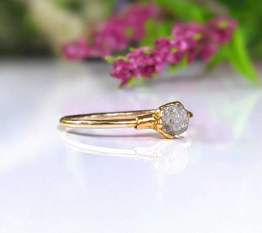 Raw diamond engagement ring set in solid 14k gold, radiating rustic elegance and unique charm.