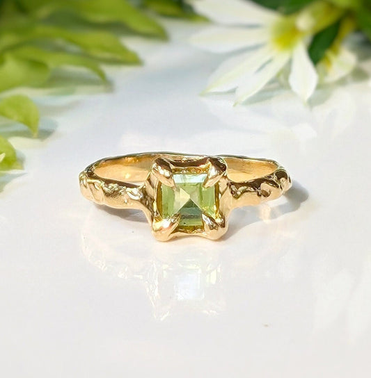 Solid 14k gold handcrafted Peridot ring with organic textured band and princess-cut gemstone.