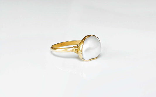 A Solid 14k Gold ring featuring a large Freshwater Pearl