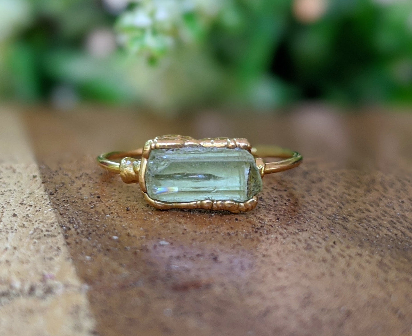 Raw yellow Apatite ring with 14k gold filled band, 8-12mm, displayed on wooden surface.