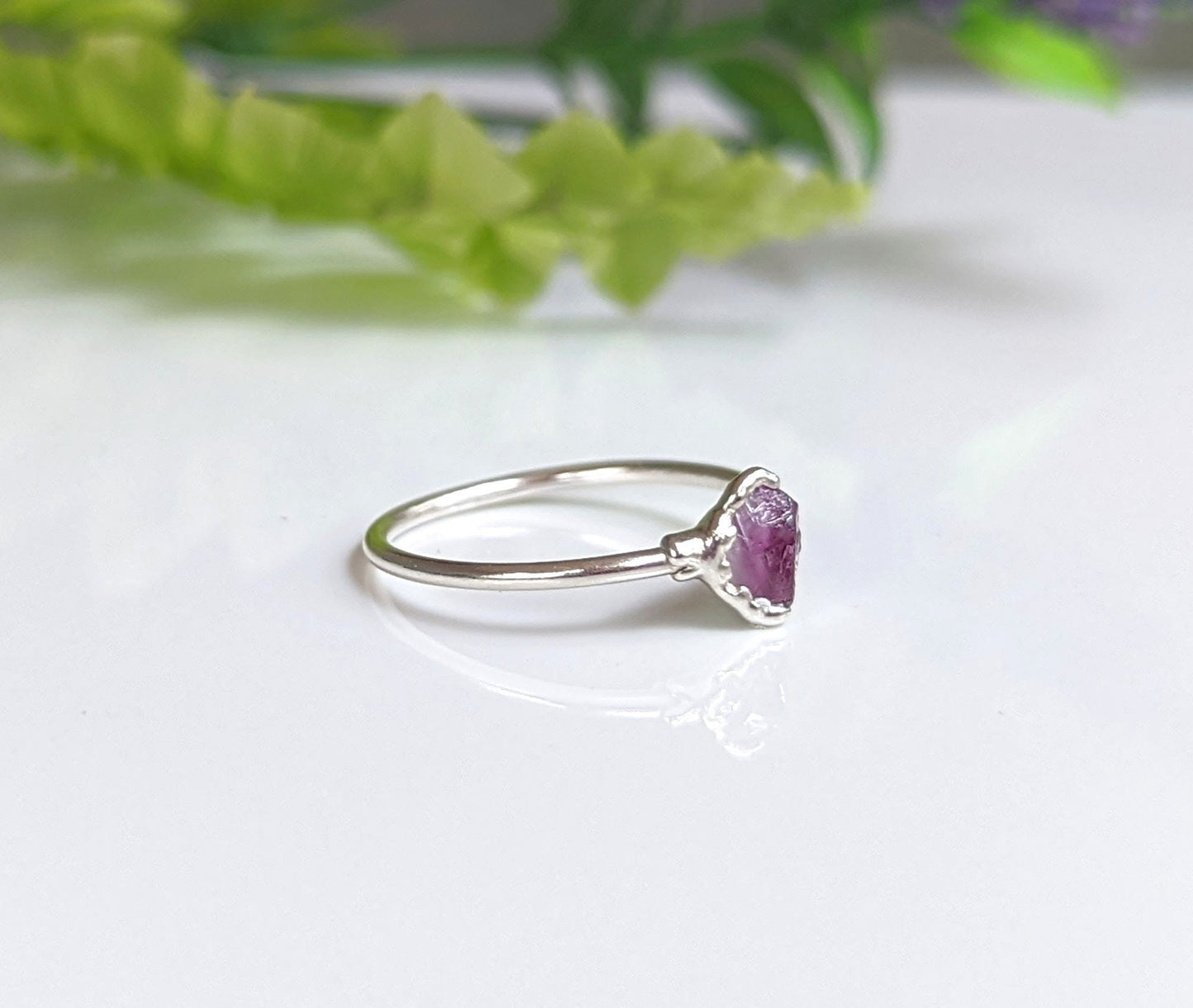 Raw Alexandrite silver ring on a shiny surface, showcasing a unique design for June birthdays or as a loved one's gift.