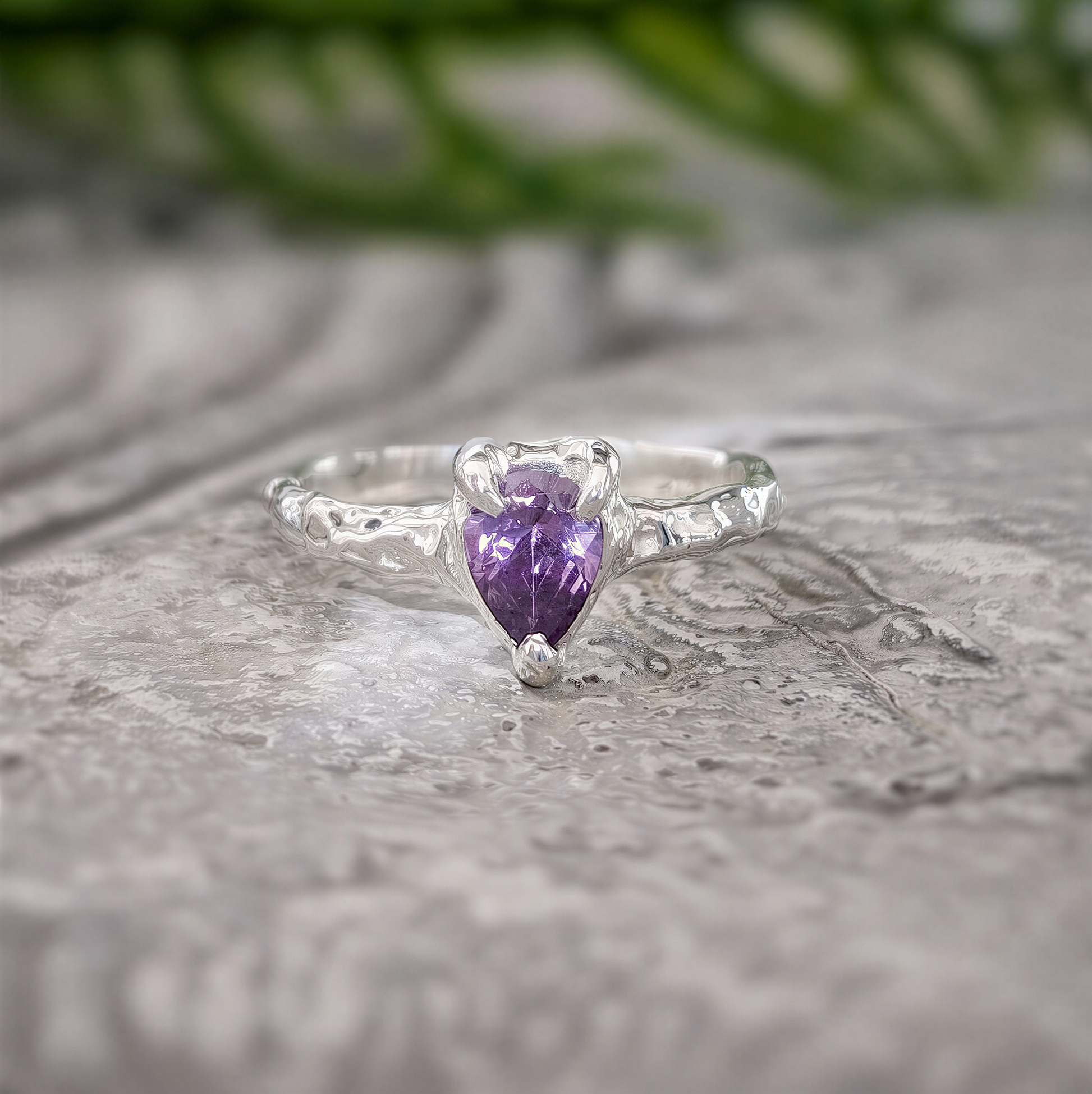 Amethyst engagement ring in solid sterling silver with pear-shaped gemstone on a textured band.