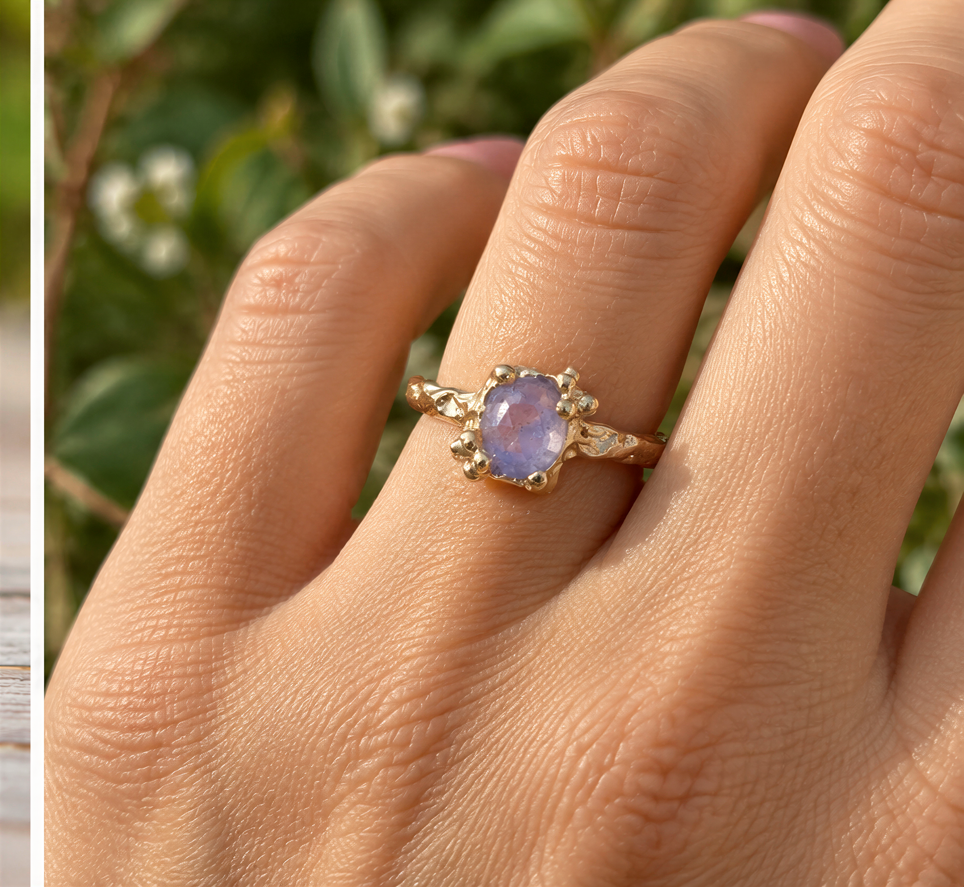 A close-up of a gold ring with a purple gemstone on a person's finger.