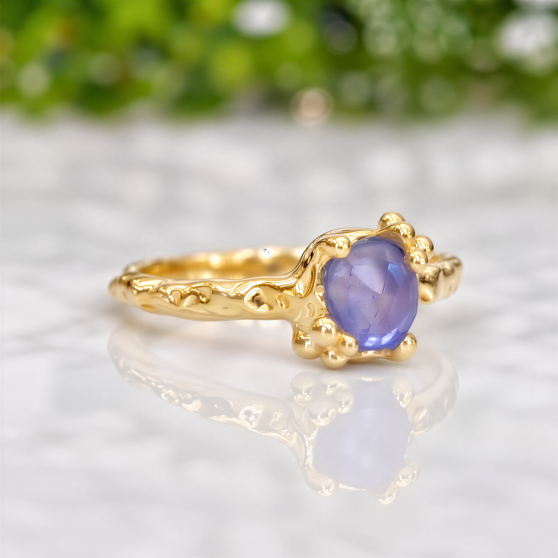 A gold ring with a large, deep blue sapphire gemstone set in a decorative gold band.