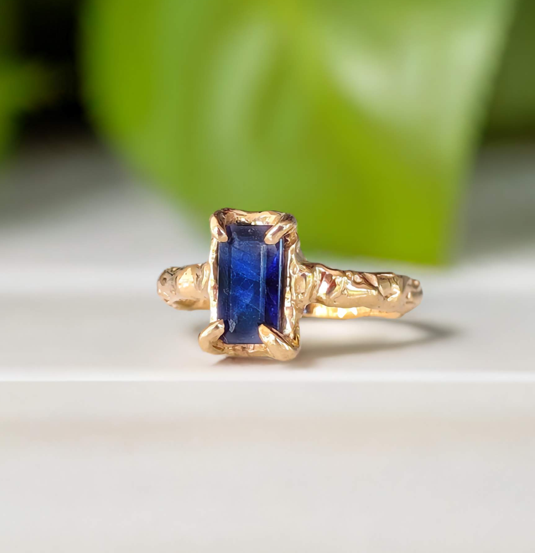 Handcrafted Blue Sapphire cocktail ring in solid 14k gold, featuring an emerald shape lab-created Sapphire with textured band.