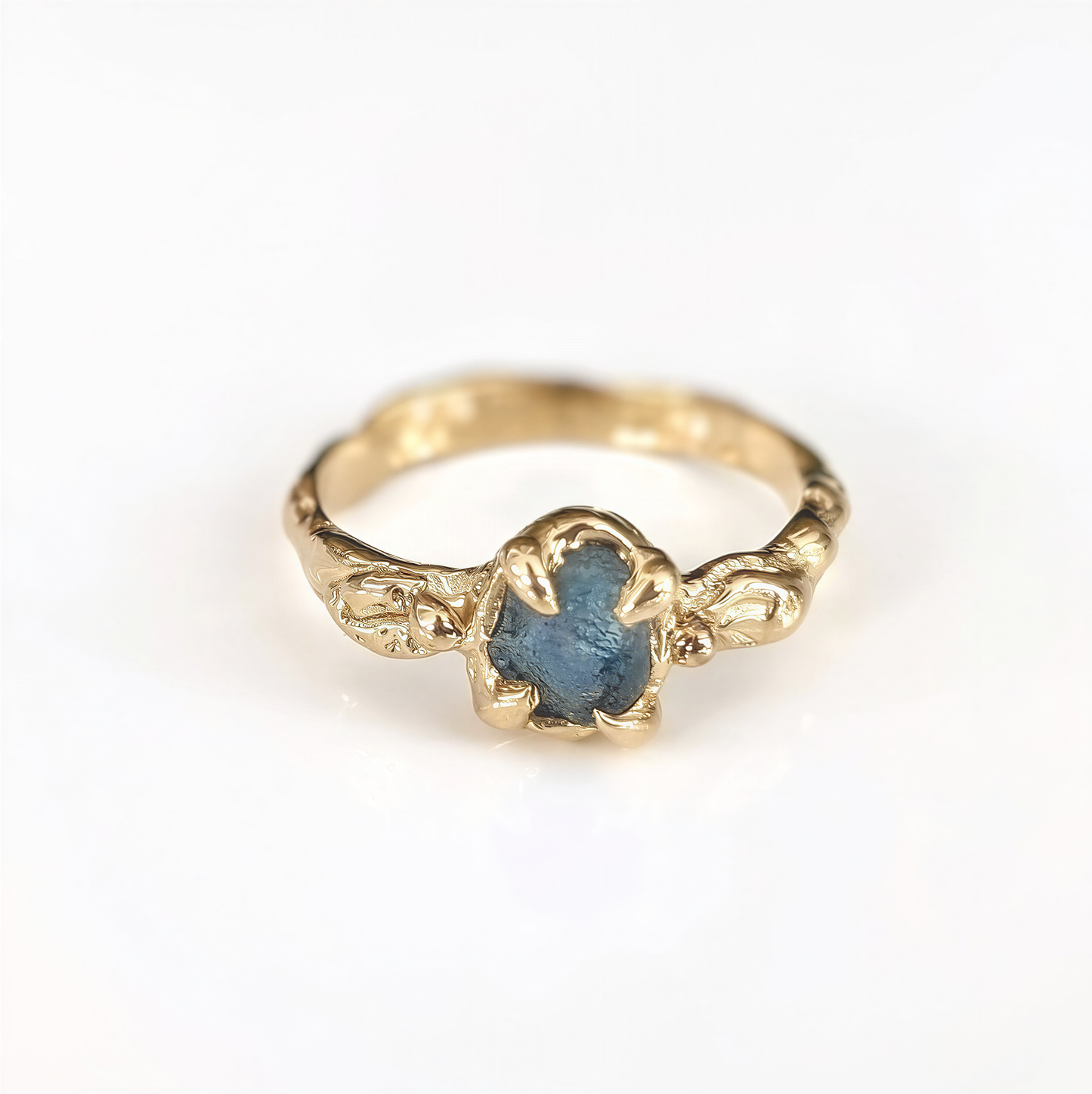Raw Montana Sapphire engagement ring in solid 14k gold, featuring an organic textured band and unique teal stone.