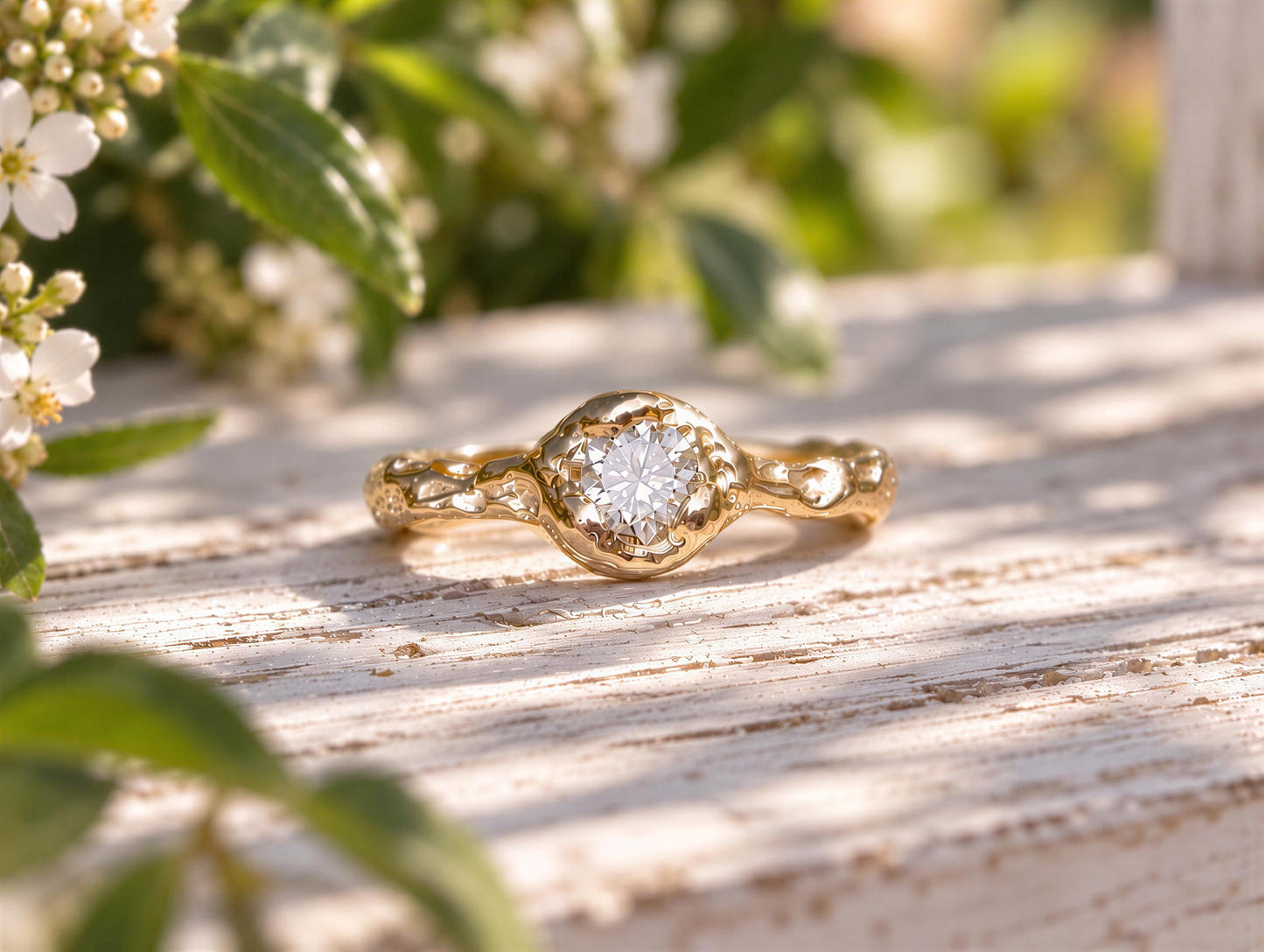 A gold ring with a large diamond set in the center, resting on a wooden surface with green leaves in the background.