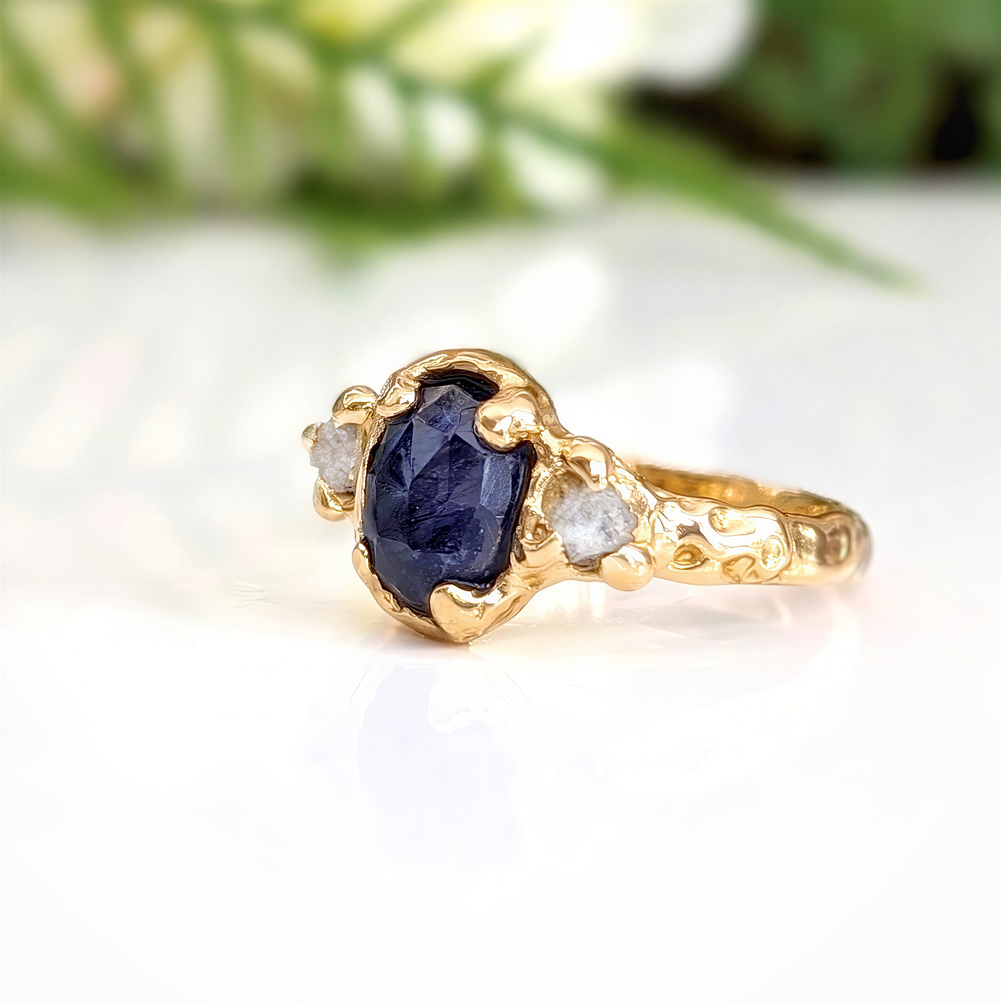 Blue Sapphire and diamond engagement ring in 14k gold with unique textured design, showcasing a stunning sapphire and raw diamonds.