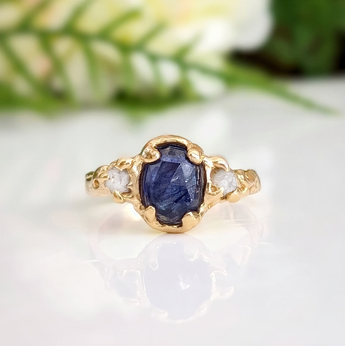 Close-up of natural blue sapphire and silver-white raw diamonds in textured gold