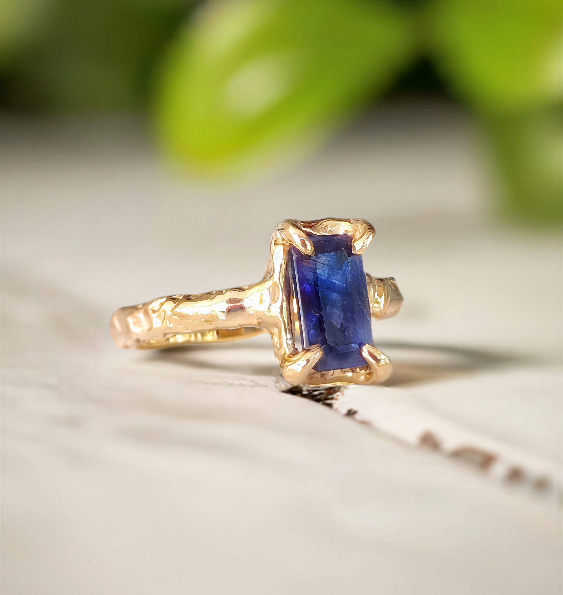 Blue sapphire cocktail ring in solid 14k gold with organic textured band, showcasing emerald shape lab-created sapphire.