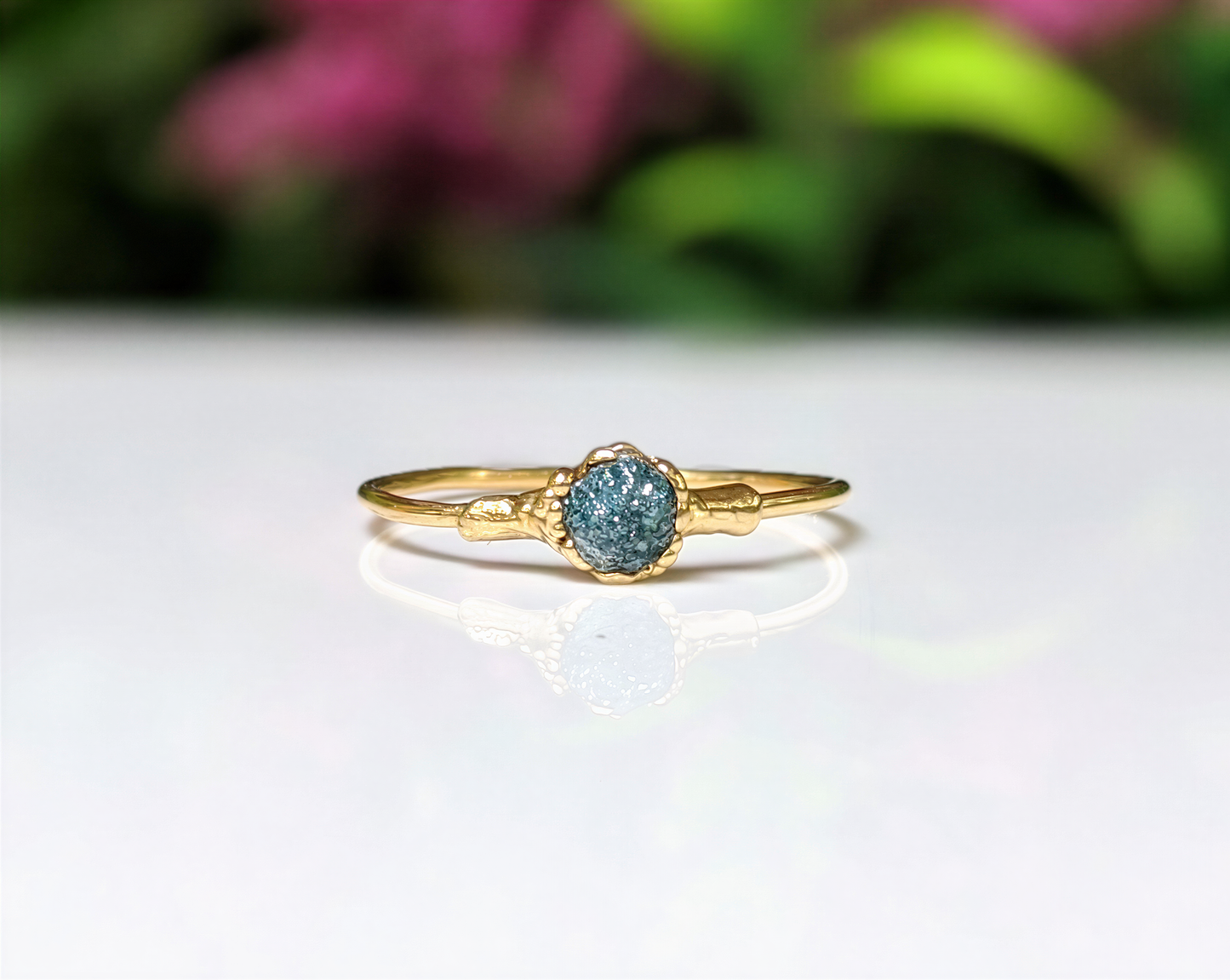 Raw blue diamond engagement ring on an 18k gold band, handcrafted and unique for special occasions.