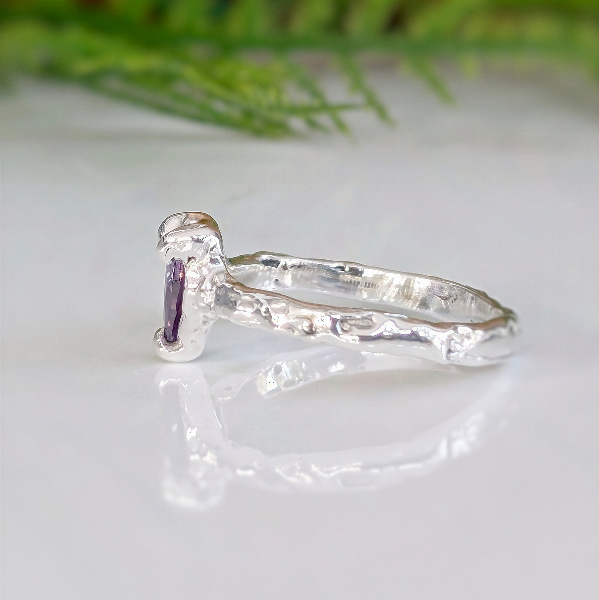 Amethyst engagement ring in solid sterling silver with a textured band and pear-shaped purple crystal, handcrafted design.