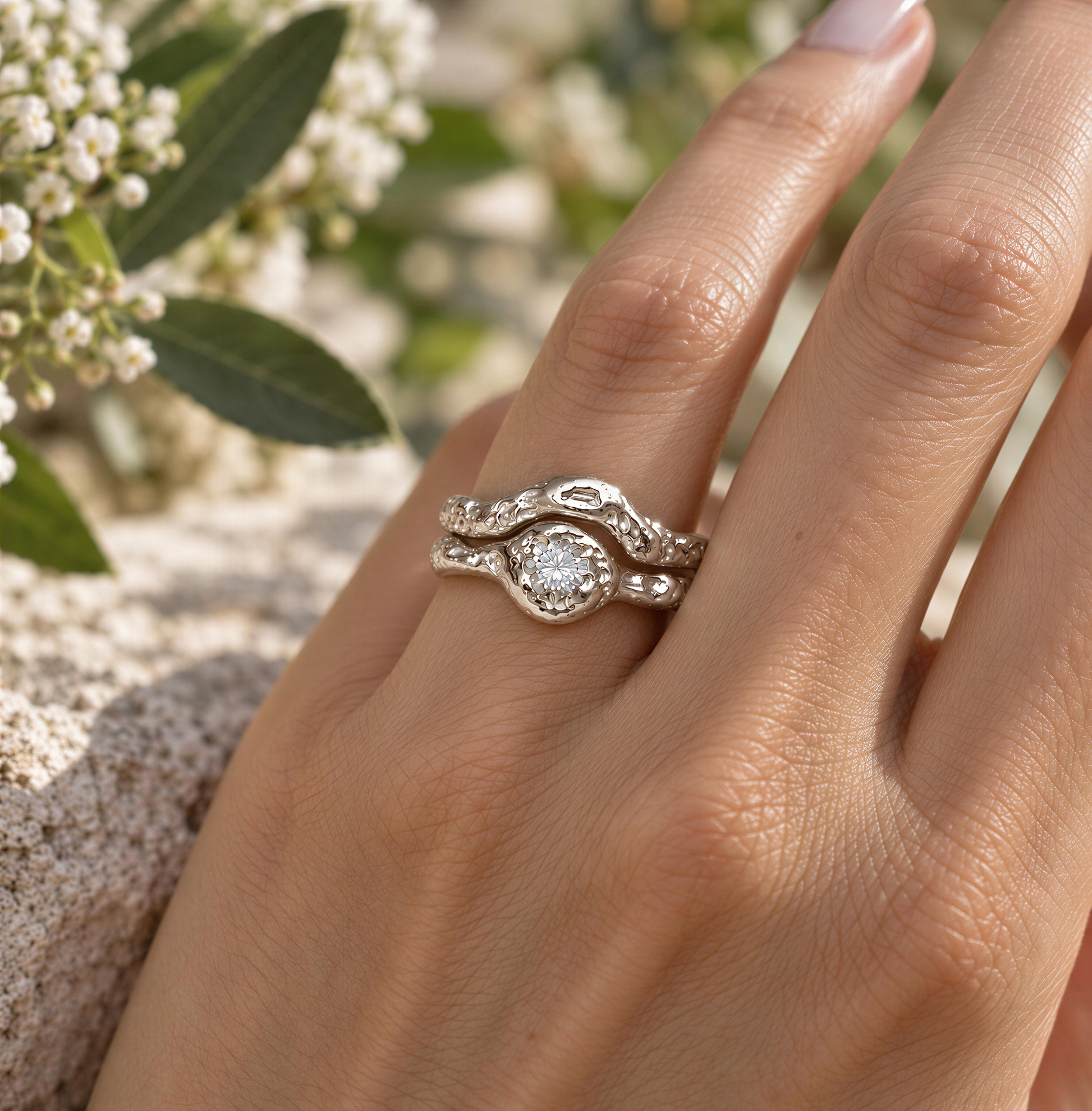 A close-up of a person's hand wearing a silver ring with a large diamond set in the center.