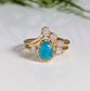 Raw Peruvian Opal and diamond engagement ring set in gold, showcasing a stunning aqua-blue opal and sparkling diamonds.