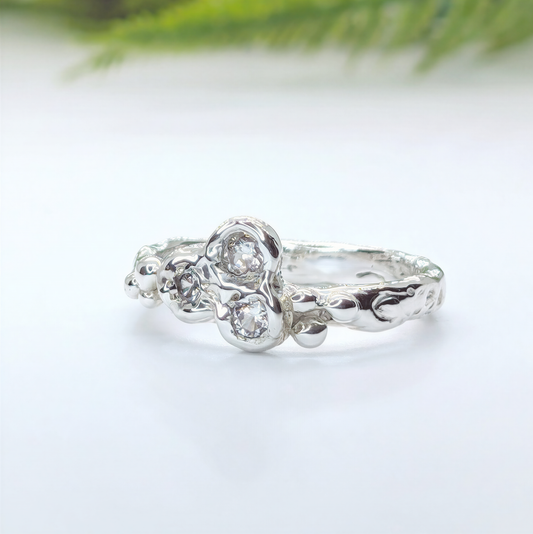 Sterling silver cubic zirconia cluster ring showcasing an organic molten band and sparkling stones.