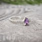Amethyst engagement ring in solid sterling silver with pear-shaped purple crystal and textured band.