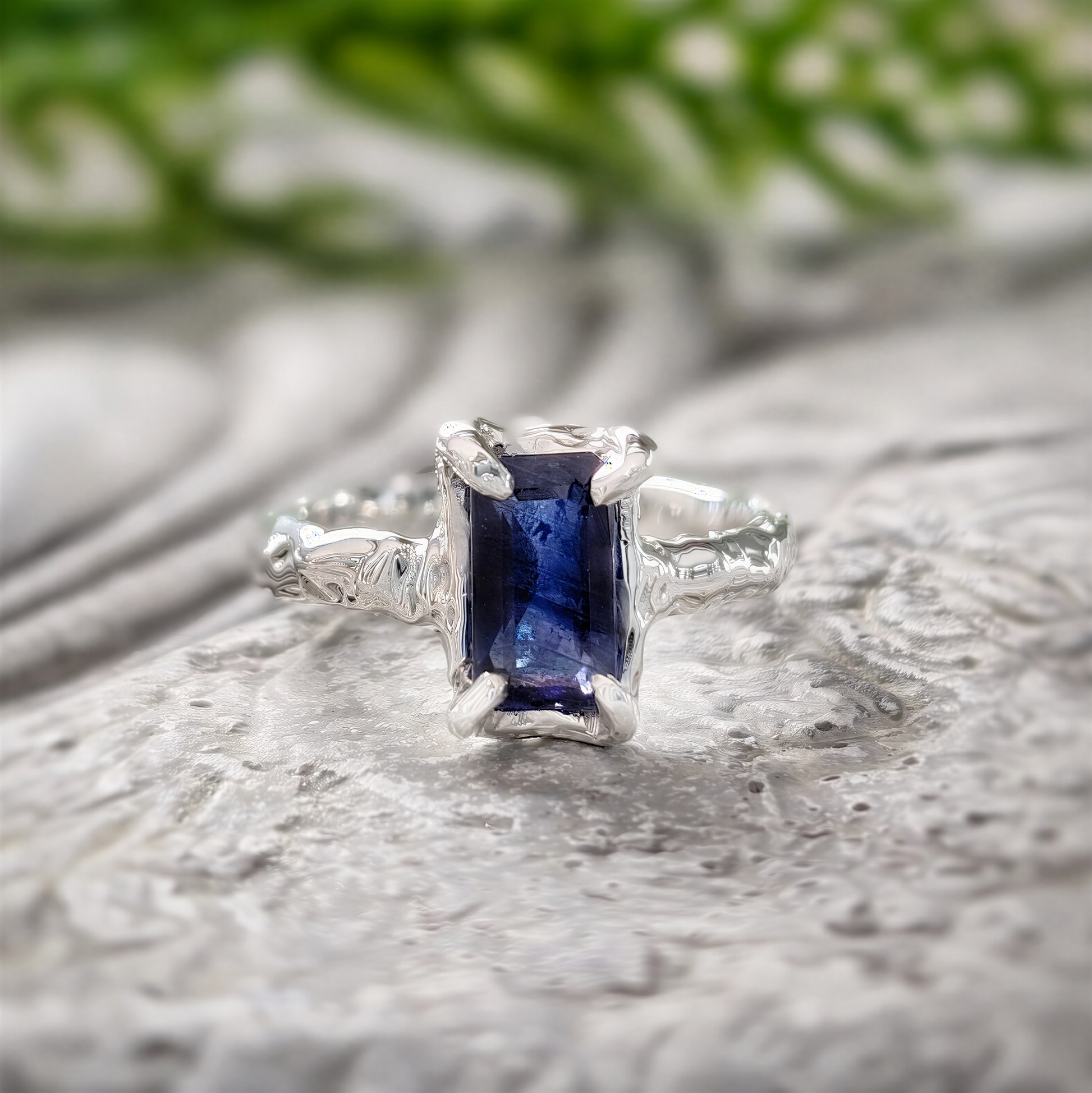 Blue Sapphire engagement ring in solid 14k gold with an emerald-cut lab-created stone and textured band.