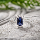 Blue Sapphire engagement ring in solid 14k gold with an emerald-cut lab-created stone and textured band.