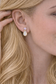 Close-up of a woman wearing a pair of Amethyst and Opal Gold stud earrings