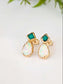 Gold earrings with green and white gemstones on a light background