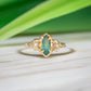 Emerald and diamond engagement ring, featuring a marquise cut emerald and salt & pepper diamonds in 14k gold.