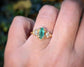 Emerald and diamond engagement ring with marquise cut emerald and salt & pepper diamonds in 14k gold setting.