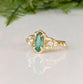 Emerald and diamond engagement ring in 14k gold with marquise cut emerald and salt & pepper diamonds.