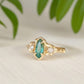 Emerald and diamond engagement ring in solid 14k gold with marquise cut emerald and salt & pepper diamonds.