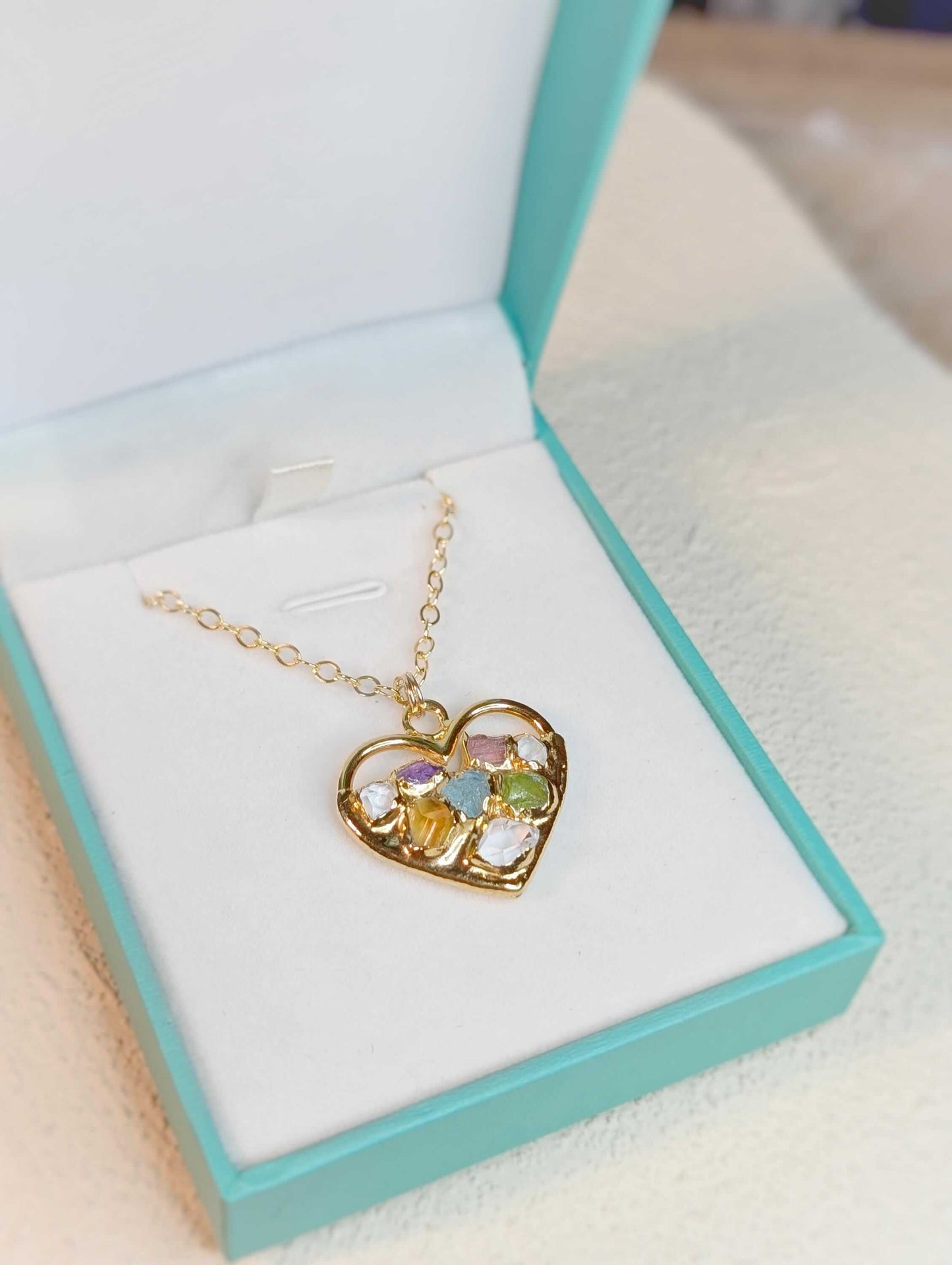 Heart-shaped custom family birthstone necklace in gold, displayed in a turquoise box, perfect for Mother's Day.