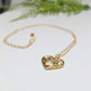Heart-shaped gold necklace with colorful birthstones, symbolizing family love and connection.