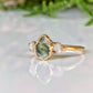 Moss Agate and Herkimer diamond engagement ring on a gold band, showcasing a pear-shaped Moss Agate with raw Herkimer diamonds.