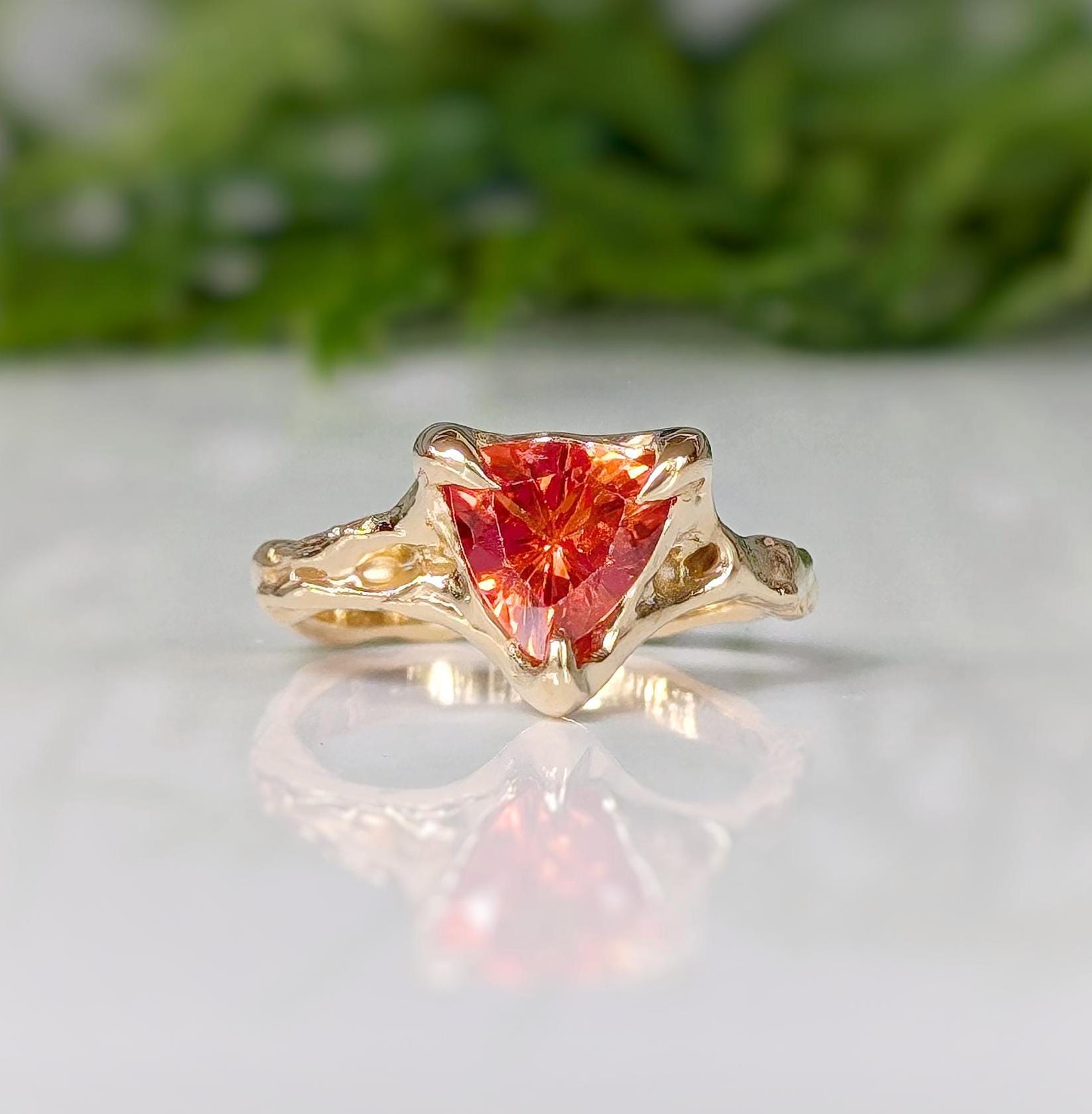 Orange sapphire trilliant cut ring in solid 14k gold with a textured organic band, handcrafted design.