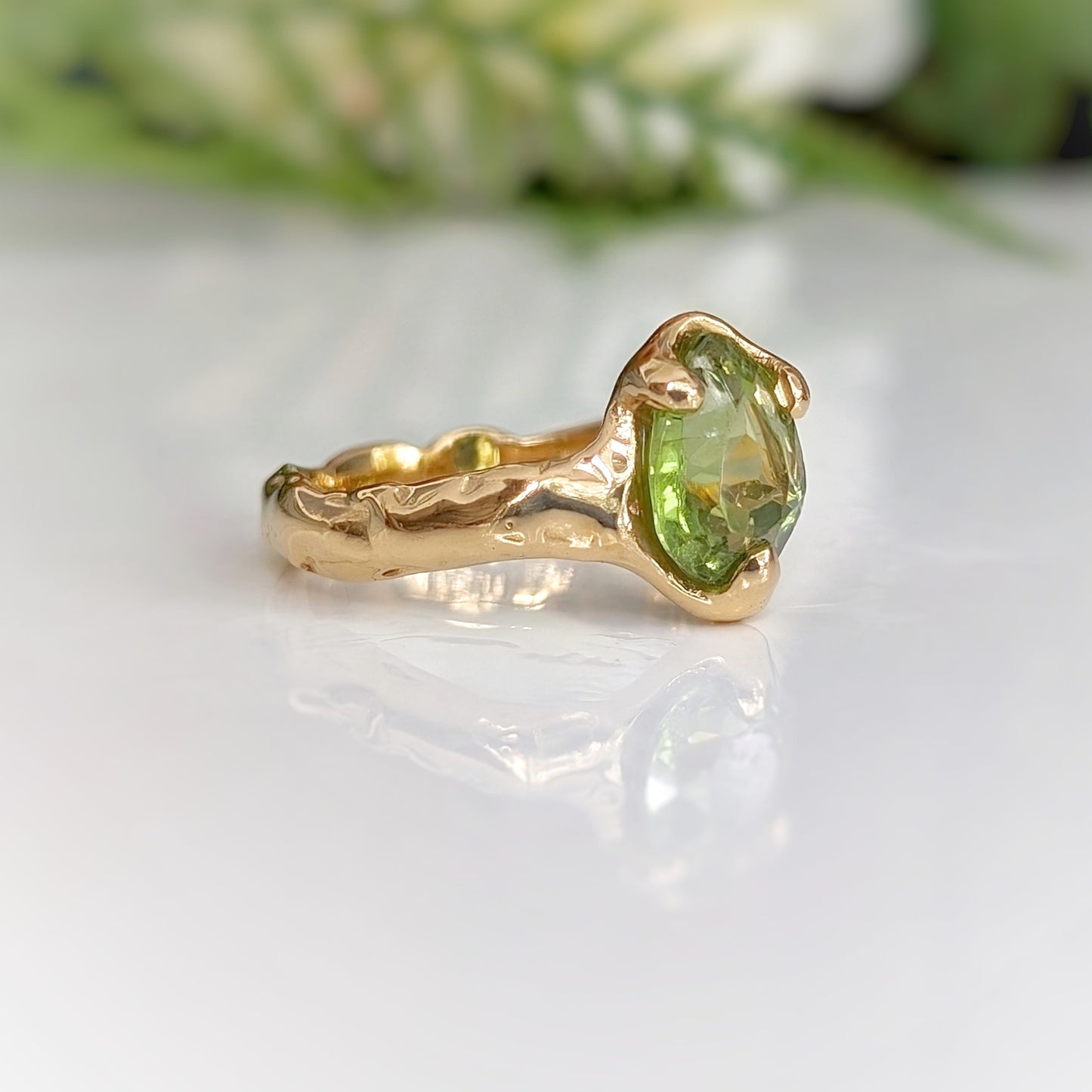 Handcrafted gold Peridot ring with an organic textured band, showcasing a stunning rose cut green gemstone.