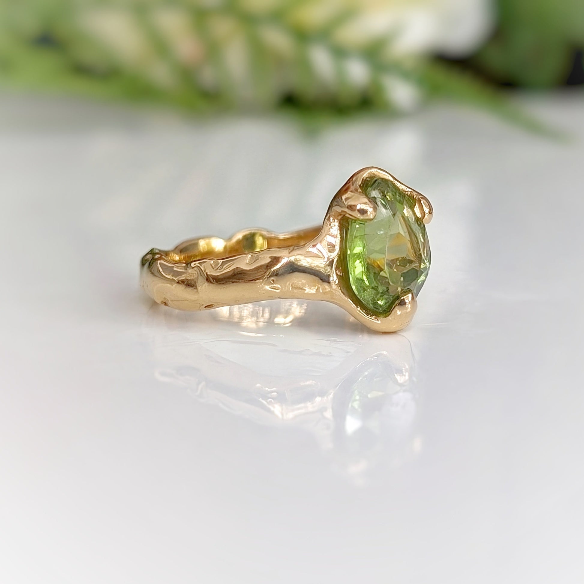 Handcrafted gold Peridot ring with an organic textured band, showcasing a stunning rose cut green gemstone.