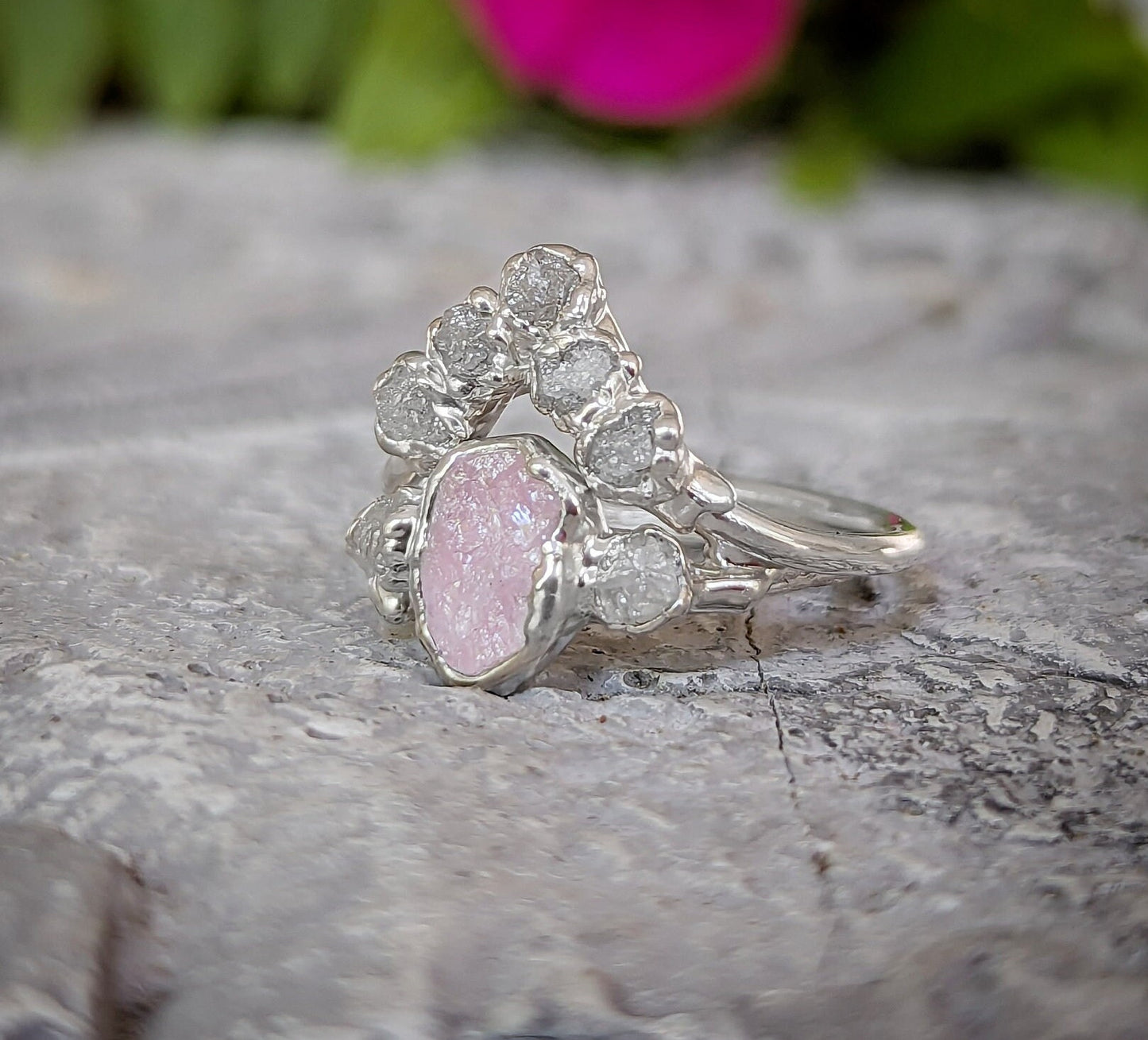 Silver diamond ring with pink Morganite on a textured surface