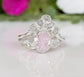 Silver Chevron style ring set with a pink Morganite and raw diamonds on a light background