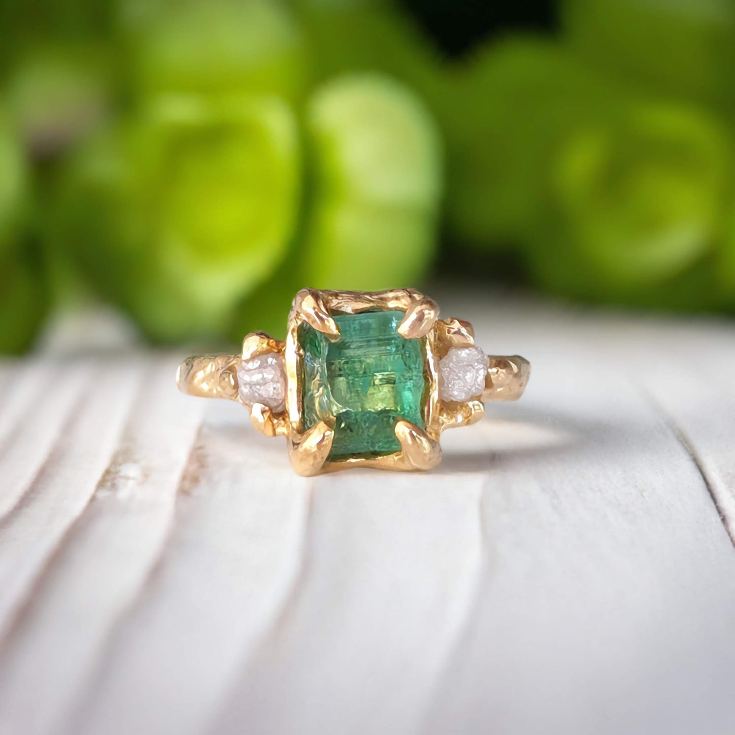 Raw emerald and diamond engagement ring in solid 14k gold with nature-inspired design, showcasing mint green emerald and two diamonds.