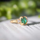 Raw emerald and diamond engagement ring in solid 14k gold, showcasing mint green emerald and two small raw diamonds.