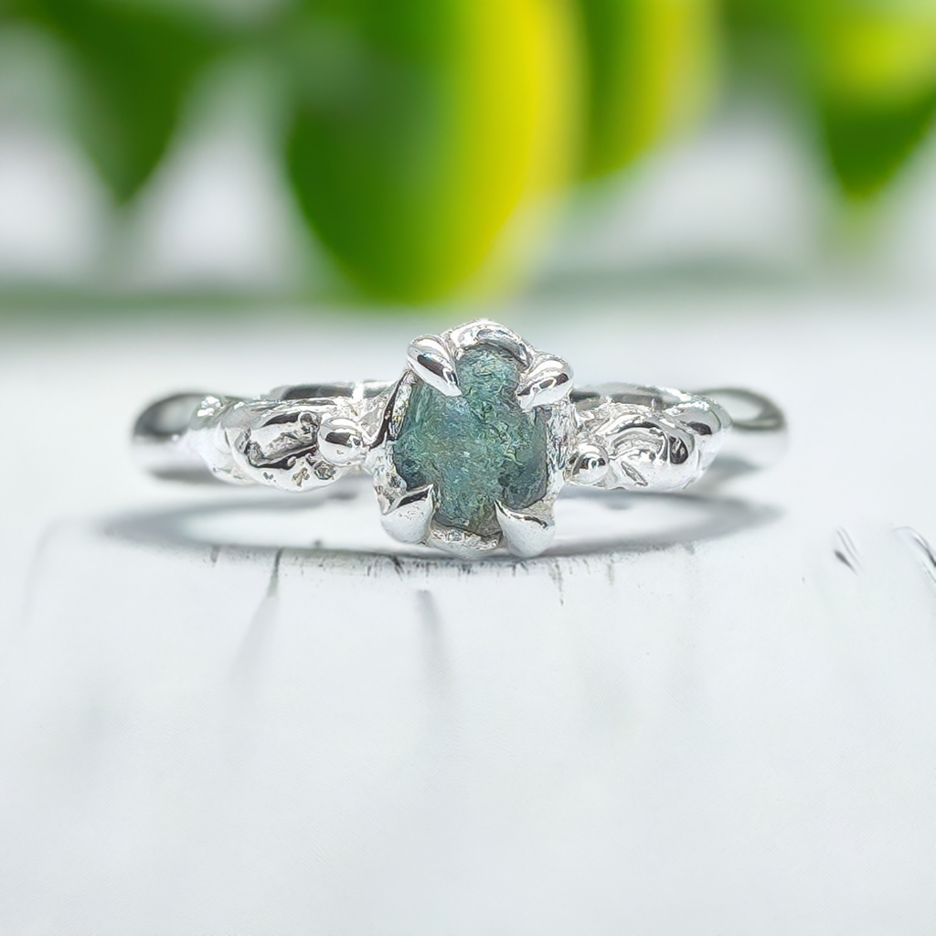 Handcrafted raw Montana Sapphire silver ring with organic band, featuring teal blue-green gemstone.
