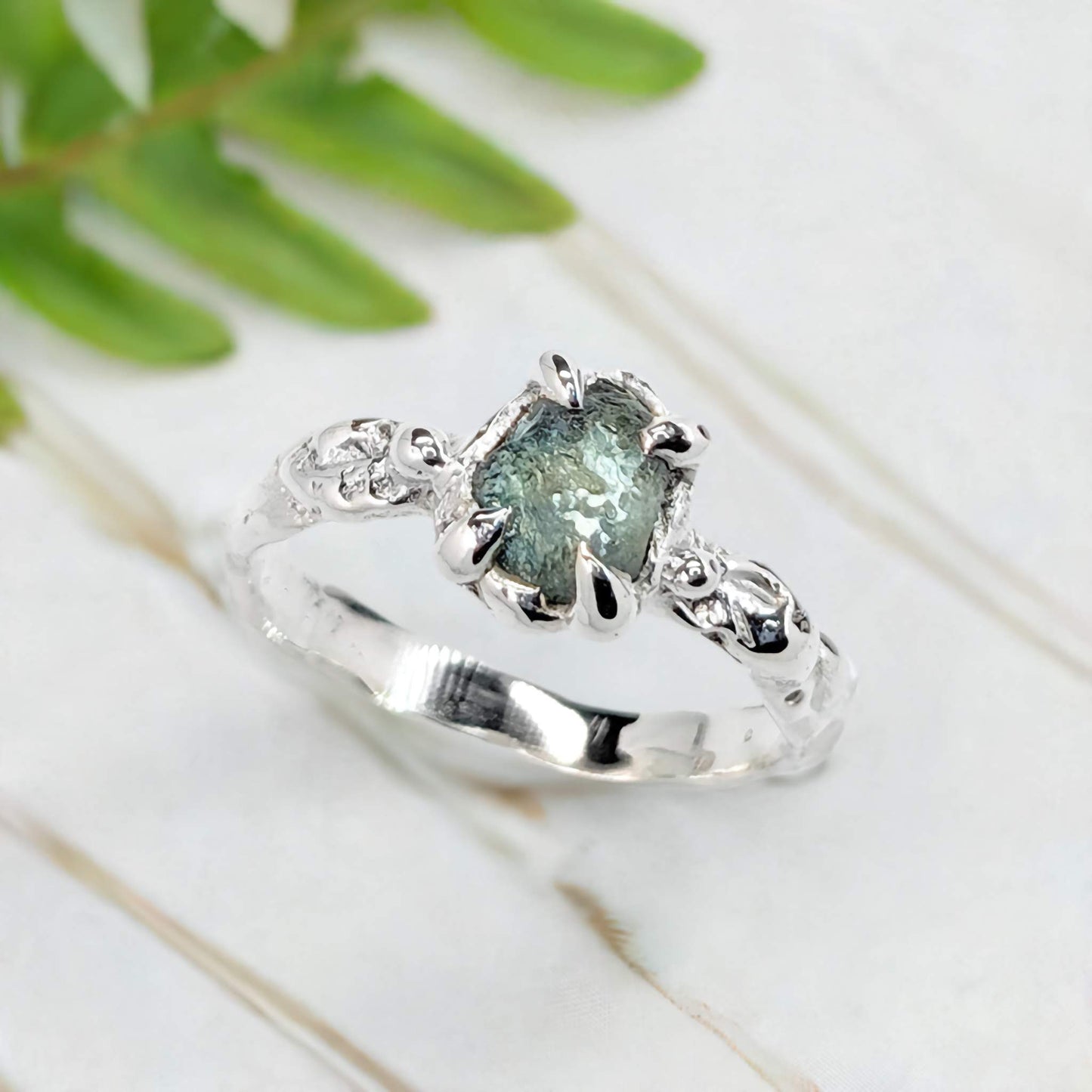 Raw Montana Sapphire silver ring with organic band, showcasing teal blue-green gemstone, perfect for unique engagement.