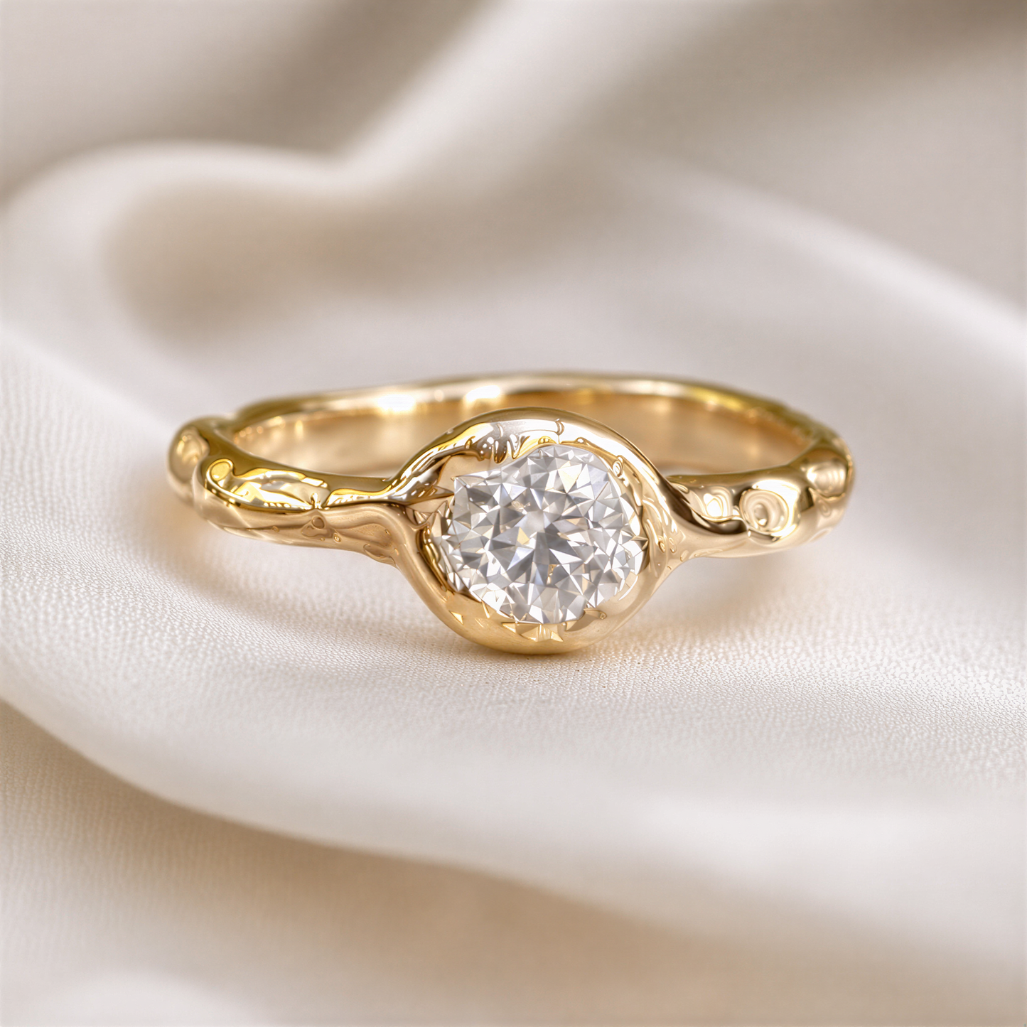 A gold textured engagement ring with a large round brilliant Moissanite set in the center, resting on a white fabric surface.
